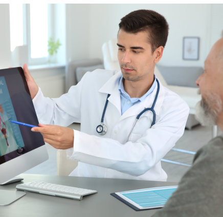 a doctor showing something on a computer to a person