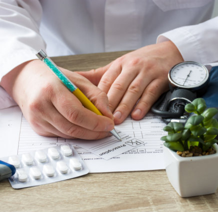 a doctor writing on a prescription