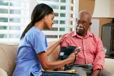  Nurse Visiting Senior Male Patient At Home Taking Notes