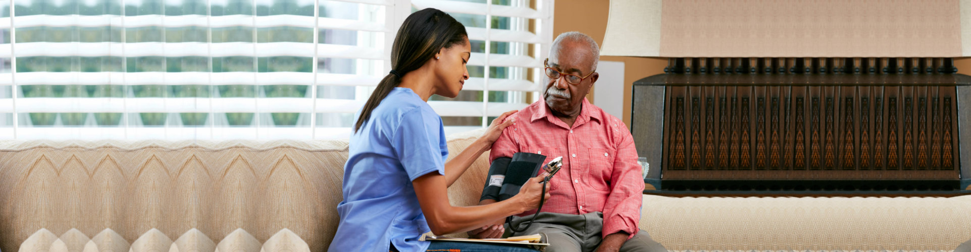 Nurse Visiting Senior Male Patient At Home Taking Notes